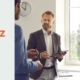 Wertschätzendes Gespräch zwischen Führungskraft und Teammitgliedern am Fenster für eine zugewandte Kommunikation und resiliente Führung im Arbeitsalltag.