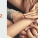 Hände verschiedener Generationen schließen sich in der Mitte zusammen für Orientierung, Zusammenhalt und feste Werte im Team.